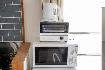 a microwave with a coffee maker on top of it at \u5927\u6cb3\u5185\u30b3\u30fc\u30dd301 \u6700\u59273\u540d \u8cb8\u5207 \u672c\u6240\u543e\u59bb\u6a4b\u99c5\u5f92\u6b6910\u5206 20\u5e73\u7c73 in Tokyo