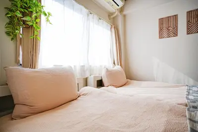 a bedroom with two beds in front of a window at Tomo House Yoyogi 302 - from 4 minutes station \u4ee3\u3005\u6728 302 \u99c5\u304b\u3089\u5f92\u6b694\u5206 in Tokyo