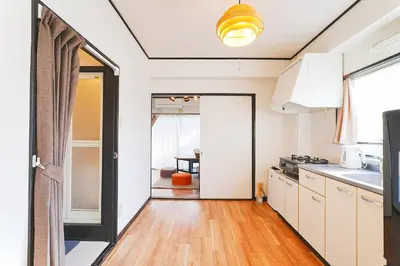 a kitchen with white cabinets and a wooden floor at Tomo House Yoyogi 302 - from 4 minutes station \u4ee3\u3005\u6728 302 \u99c5\u304b\u3089\u5f92\u6b694\u5206 in Tokyo
