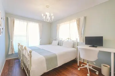 a bedroom with a bed and a desk with a television at Tomo House Nishi-Shinjuku-Gochome - from 3 minutes station \u897f\u65b0\u5bbf\u6238\u5efa\u3066 \u99c5\u304b\u3089\u5f92\u6b693\u5206 in Tokyo