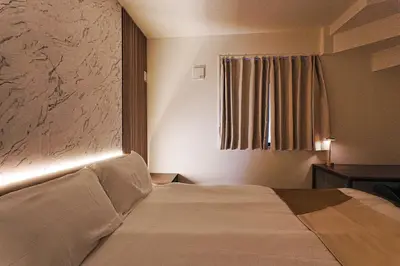 a hotel room with a bed and a window at Tomo House Nishi-Shinjuku-Gochome - from 3 minutes station \u897f\u65b0\u5bbf\u6238\u5efa\u3066 \u99c5\u304b\u3089\u5f92\u6b693\u5206 in Tokyo