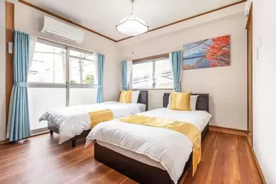 two beds in a room with two windows at Ikebukuro and Yunxuan in Tokyo