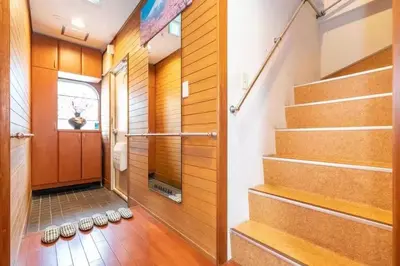 a hallway with a set of stairs with shoes at Ikebukuro and Yunxuan in Tokyo