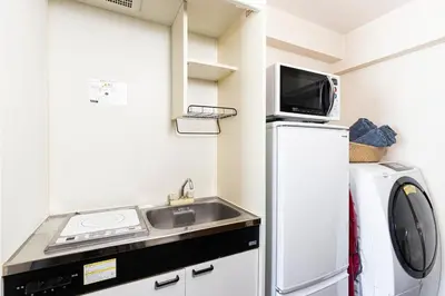 a small kitchen with a sink and a microwave at NakanoRetreat in Tokyo