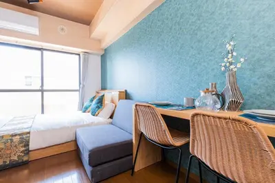 a bedroom with a bed and a desk with a table and chairs at NakanoRetreat in Tokyo