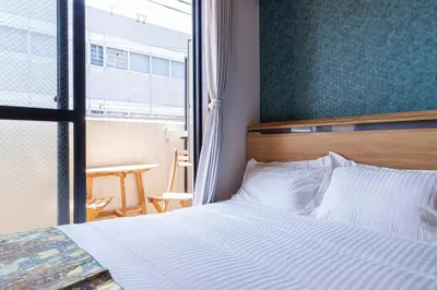 a bedroom with a white bed and a window at NakanoRetreat in Tokyo