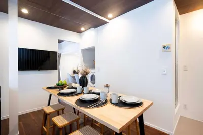 a dining room with a wooden table and chairs at \u672a\u516c\u958bB107 sumicco in Tokyo