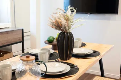a table with plates and a vase with flowers on it at \u672a\u516c\u958bB107 sumicco in Tokyo