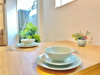 two bowls and plates sitting on a wooden table at Detached Villa 4LDK Free Parking, 4 min walk to Sengawa Station, Toshima Ward in Tokyo
