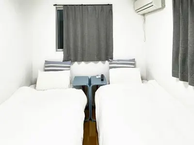 two beds in a room with white walls at Detached Villa 4LDK Free Parking, 4 min walk to Sengawa Station, Toshima Ward in Tokyo