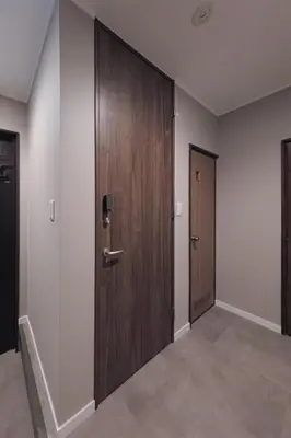 a corridor with a wooden door in a building at Breeze Stay Shiohama in Tokyo