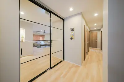 a hallway with sliding glass doors and a wooden floor at Breeze Stay Shiohama in Tokyo