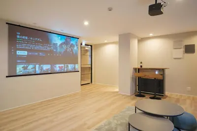 a room with two stools and a large screen on the wall at Breeze Stay Shiohama in Tokyo