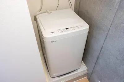 a small white washer and dryer in a corner at PASEO\u5e02\u8c37\u53f0\u753all in Tokyo
