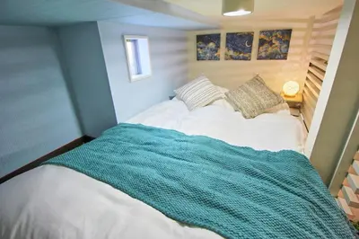 a bedroom with a bed with a blue blanket on it at Hotel Little Stay Tateishi 1F in Tokyo