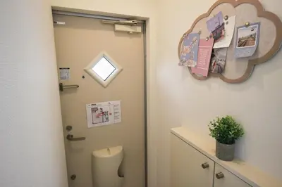 a bathroom with a door and a toilet in a room at Hotel Little Stay Tateishi 1F in Tokyo