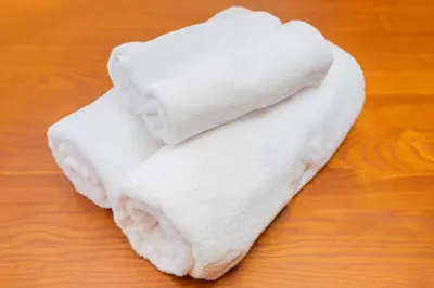 a white towel sitting on top of a wooden table at Shinjuku Homely Stay in Tokyo