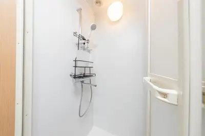 a shower in a bathroom next to a door at Shinjuku Homely Stay in Tokyo