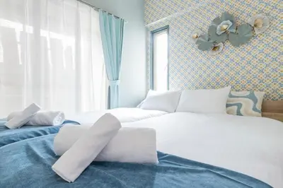 two beds in a room with blue and white at Shinjuku Homely Stay in Tokyo
