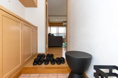 a hallway with a black toilet and a row of shoes at Mi-APT Nakaitabashi Near Ikebukuro in Tokyo