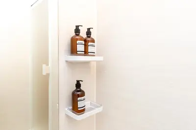 two bottles of alcohol sit on shelves in a door at Mi-APT Nakaitabashi Near Ikebukuro in Tokyo