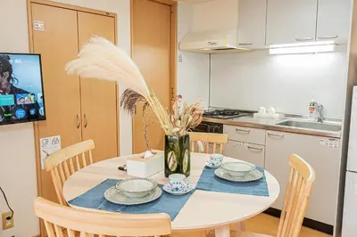 a kitchen with a table with plates and flowers on it at Mi-APT Nakaitabashi Near Ikebukuro in Tokyo
