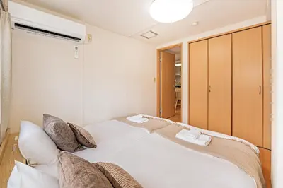 a bedroom with a large white bed with pillows at Mi-APT Nakaitabashi Near Ikebukuro in Tokyo