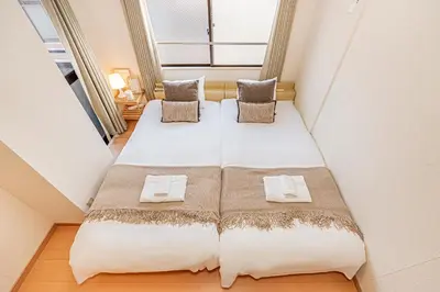 two beds in a small room with a window at Mi-APT Nakaitabashi Near Ikebukuro in Tokyo