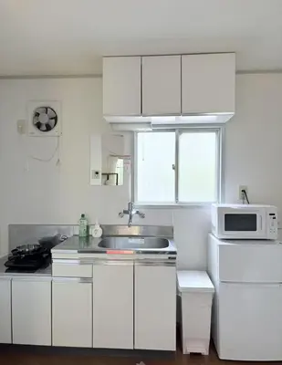 a white kitchen with a sink and a microwave at JapanHouse Takadanobaba #Shinjuku Area in Tokyo