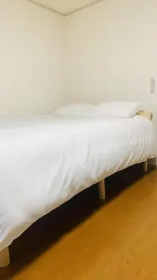 a white bed with white sheets and pillows on it at JapanHouse Takadanobaba #Shinjuku Area in Tokyo