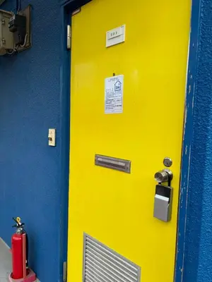 a yellow door on a blue wall with a fire hydrant at JapanHouse Takadanobaba #Shinjuku Area in Tokyo