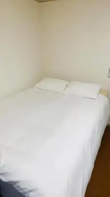 a white bed with two pillows on top of it at JapanHouse Takadanobaba #Shinjuku Area in Tokyo