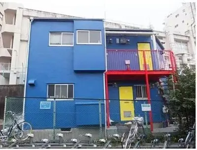 a blue building with colorful doors in a city at JapanHouse Takadanobaba #Shinjuku Area in Tokyo