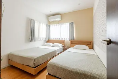 a bedroom with two beds and a window at Guest Residence Kanamecho in Tokyo