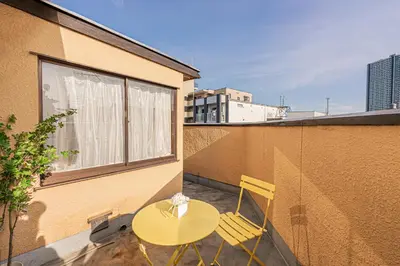 a yellow table and two chairs on a balcony at Mori hotel \u5341\u6761401 in Tokyo