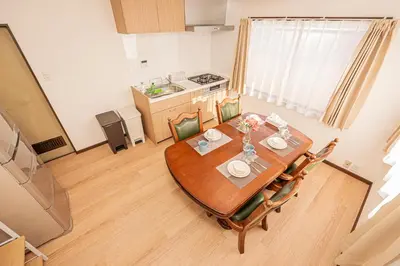 a dining room table with chairs and a kitchen at Mori hotel \u5341\u6761401 in Tokyo