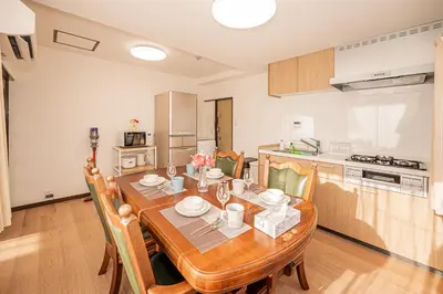 a kitchen and dining room with a wooden table and chairs at Mori hotel \u5341\u6761401 in Tokyo