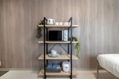 a room with a shelf with a microwave and a bed at CraftFlat Numabukuro 305, uphill residence monthly stay in Tokyo