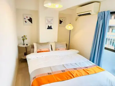 a bedroom with a bed with an orange and white blanket at Ikebukuro\u4e2d\u5ddd6H-TS0037 in Tokyo