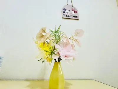 a yellow vase filled with flowers on a table at Ikebukuro\u4e2d\u5ddd6H-TS0037 in Tokyo