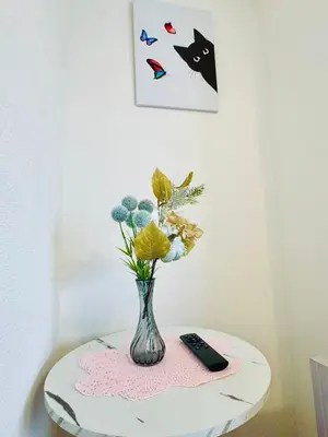 a vase with flowers on a table with a remote control at Ikebukuro\u4e2d\u5ddd6H-TS0037 in Tokyo