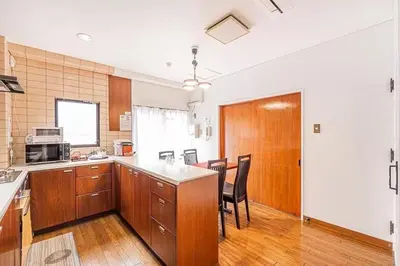 a kitchen with wooden cabinets and a table and chairs at My Sumida Home B in Tokyo