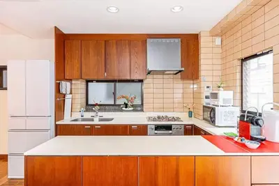 a kitchen with wooden cabinets and a white refrigerator at My Sumida Home B in Tokyo