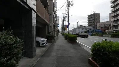 a street with a white car parked on the side of a building at Sakura house in Tokyo