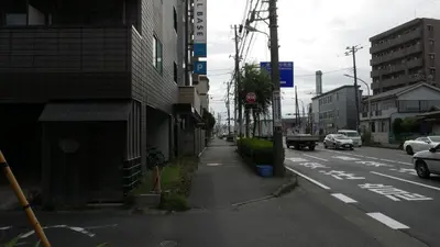 an empty city street with cars driving down the street at Sakura house in Tokyo