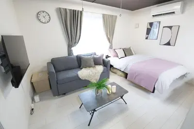 a bedroom with a bed and a couch and a tv at \u6e0b\u8c37\u533a\u4ee3\u3005\u6728302 in Tokyo