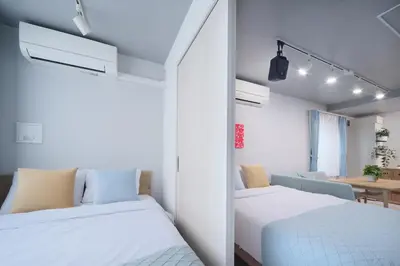 two beds in a small room with a table at Monzen-nakacho 1LDK with projector, 2 double beds,301 in Tokyo