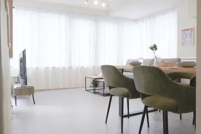 a dining room with a table and green chairs at \u5922\u306e\u820e\u4e0a\u5317\u6ca2 Yumenoya Kamikitazawa in Tokyo