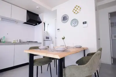 a kitchen with a wooden table and chairs at \u5922\u306e\u820e\u4e0a\u5317\u6ca2 Yumenoya Kamikitazawa in Tokyo