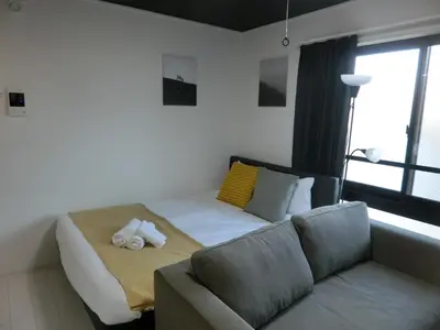 a room with a bed and a couch and a window at \u6e0b\u8c37\u533a\u4ee3\u3005\u6728402 in Tokyo